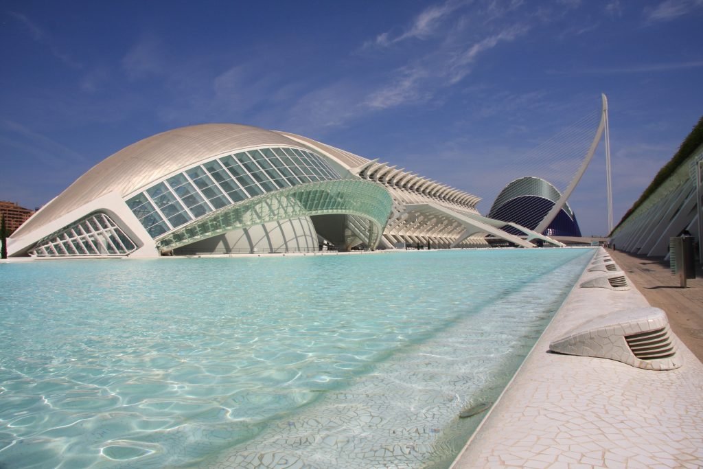 Futuristic architecture with poolside view in Valencia showcasing modern design under a clear sky.